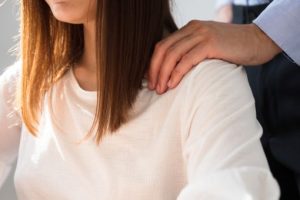 女性の肩に手をあてる男性
